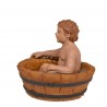 Niño sentado en barreño bañándose